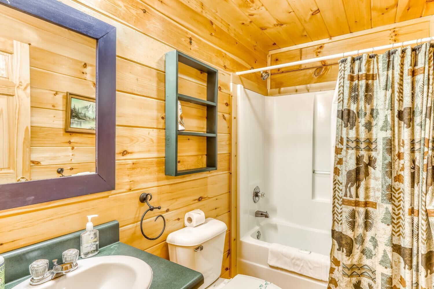 A wooden cabin bathroom with a sink, toilet, and shower.
