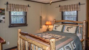A bedroom with a wooden bed frame, plaid curtains, a ceiling fan, and a window with blinds.