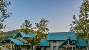 Un chalet composé de deux bâtiments principaux, chacun doté d’un toit végétalisé et d’une véranda.
