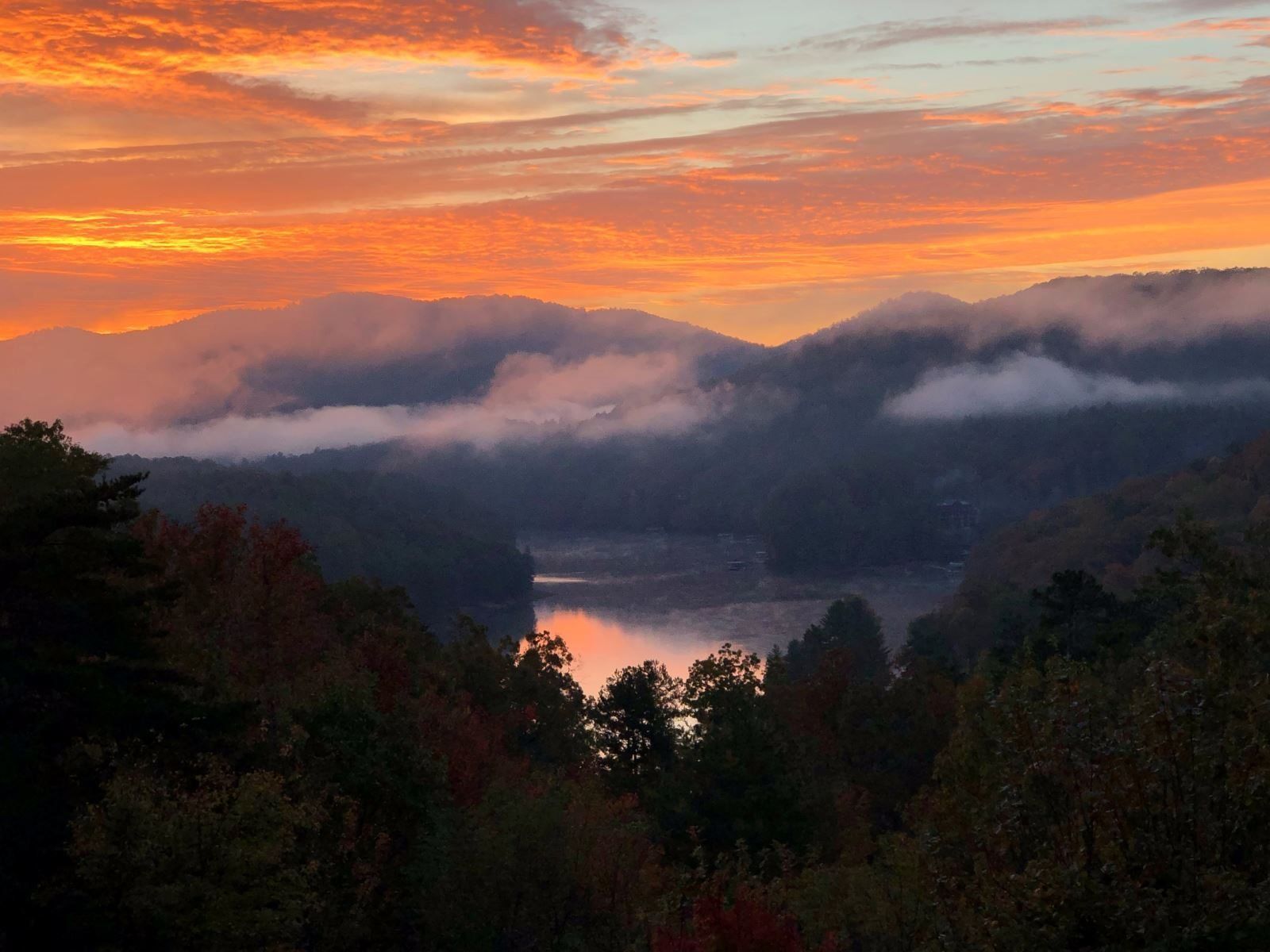 A mountainous landscape with a lake and forested area.