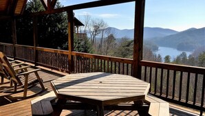 A wooden deck with a table and chairs, overlooking a lake and mountains. - Light`s Mountain Lake Overlook (Blue Ridge)