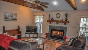 A cozy living room with a fireplace, a television, and comfortable seating.