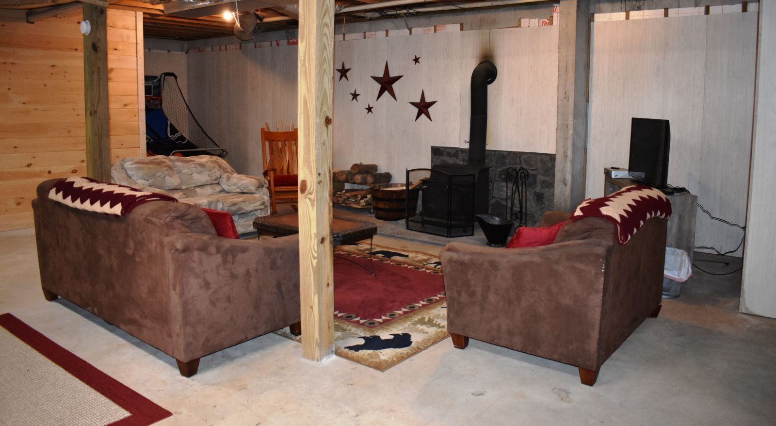 A cozy living room with two brown sofas, a fireplace, and a television.