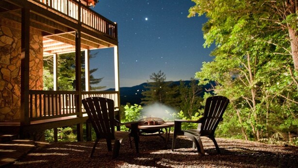 An outdoor seating area with two Adirondack chairs, a table, and a fire pit. - Three Bears Bluff (Cherry Log)