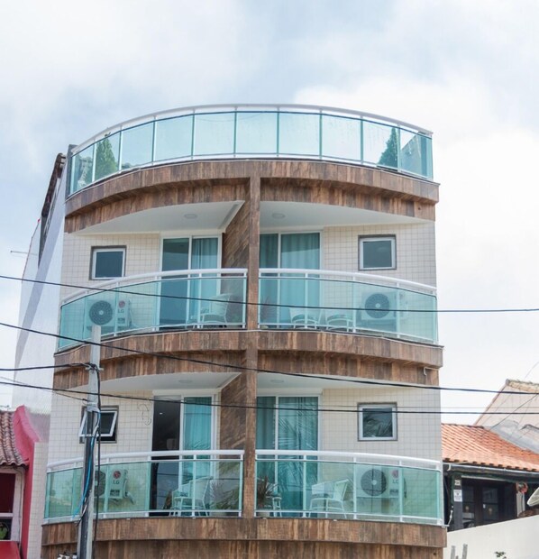 A multi-story building with balconies, glass railings, and tiled walls. - Pousada Nascer do Sol (Arraial do Cabo)