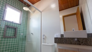 A bathroom with a glass shower enclosure, a toilet, and a sink with a mirror above it. - Pousada Nascer do Sol (Arraial do Cabo)