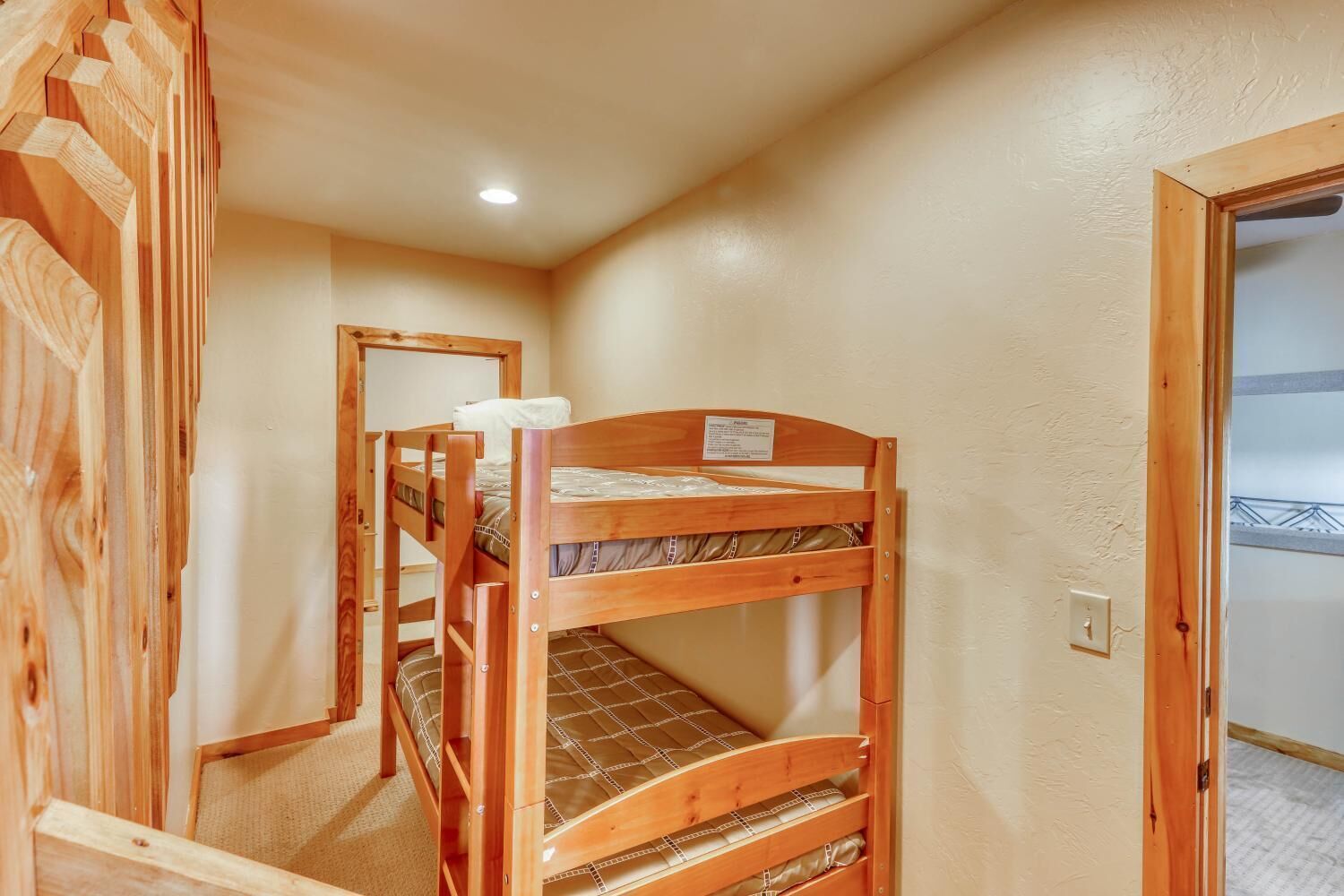 A bunk bed room with a wooden door and a small window.