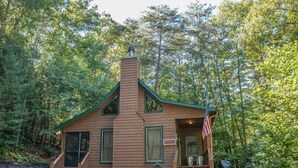 A cabin with a chimney, a porch, and an American flag. - Hackers Hideaway (Blue Ridge)
