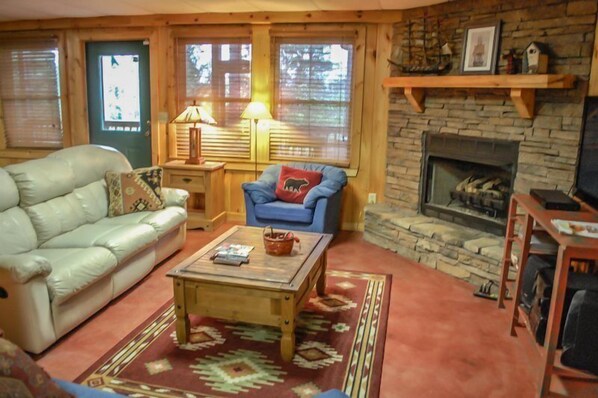 A cozy living room with a fireplace, a sofa, a chair, and a coffee table. - Overlook Retreat (Blue Ridge)