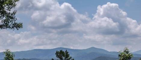 A mountainous landscape with dense forest and a clear sky.