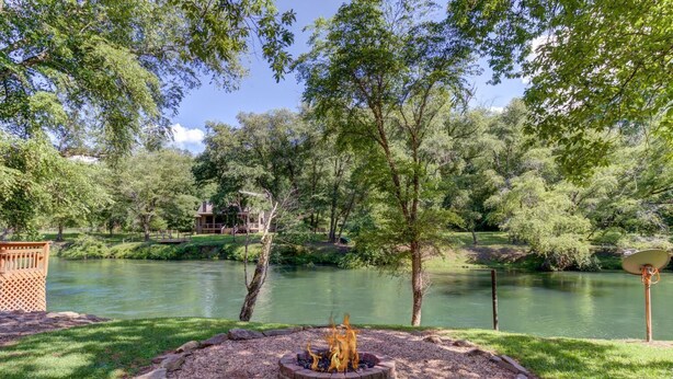 A serene outdoor area with a fire pit, a pond, and a wooden deck. - Fish Trap Cabin (Mineral Bluff)