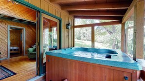 A wooden cabin with a hot tub, a bedroom, and a view of the outdoors. - Fish Trap Cabin (Mineral Bluff)