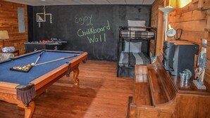 A room with a pool table, a chalkboard wall, a bunk bed, and a desk with a lamp. - My Mountain Escape (Morganton)
