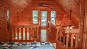A wooden cabin with a loft bedroom, a balcony, and an American flag. - Into Thin Ayer (Blue Ridge)