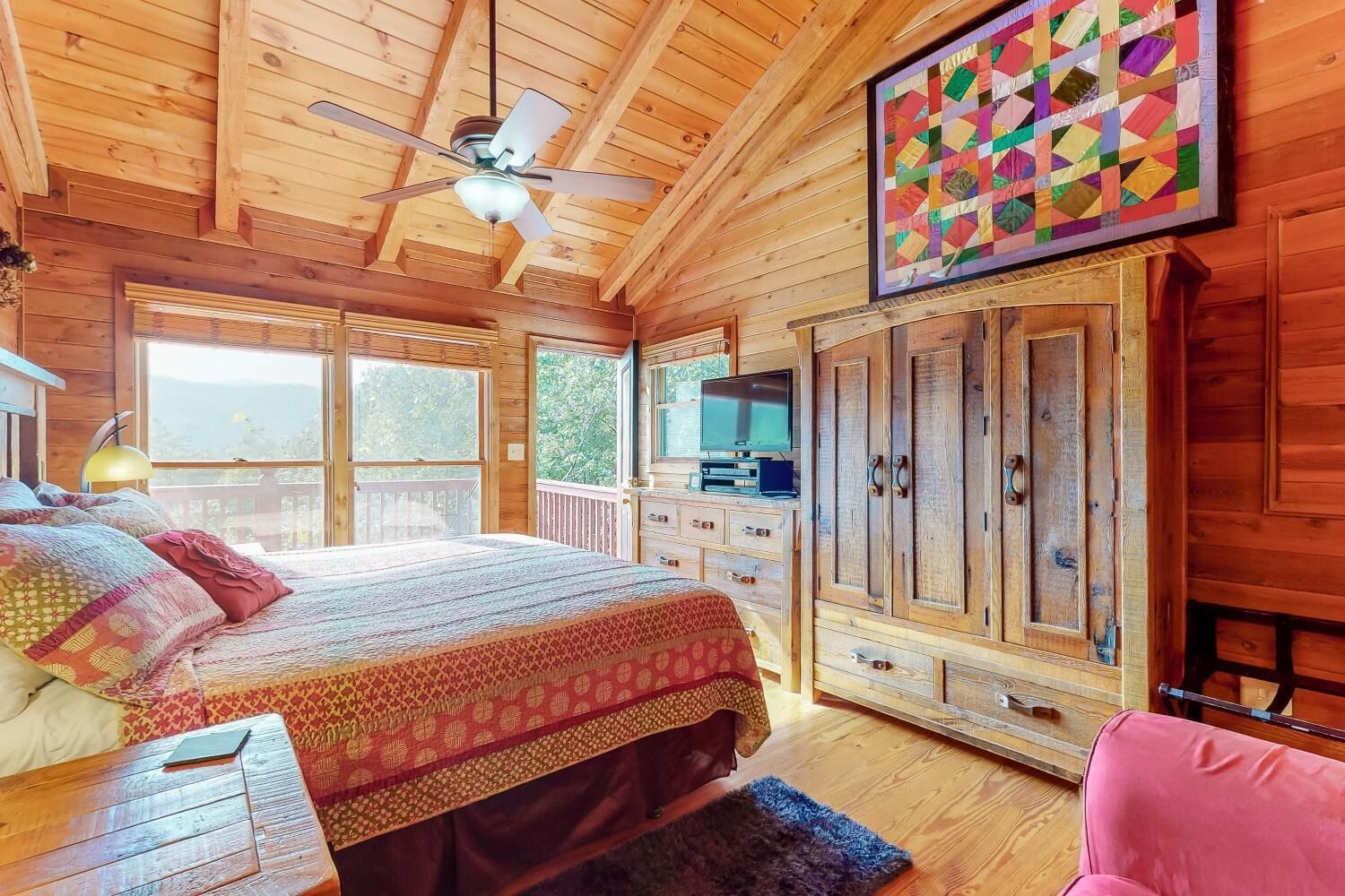 Quarto de cabana de madeira com cama, televisão e um armário grande.