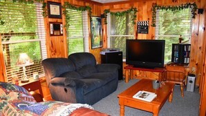 Un salon confortable avec un canapé, un téléviseur et une table basse.