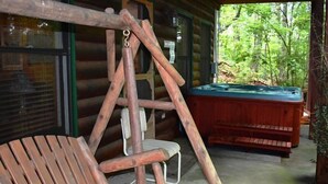 Un fauteuil suspendu en bois, une table de billard et une terrasse en bois.
