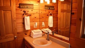 A wooden bathroom with a sink, mirror, and towel racks. - Serendipity (Blue Ridge)