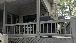 A covered porch with a wooden railing and a lattice fence. - Mountain Rivers Lodge (Mineral Bluff)