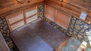 A wooden cabin with stone walls, a fireplace, and a stone hearth. - Picabo (Blue Ridge)