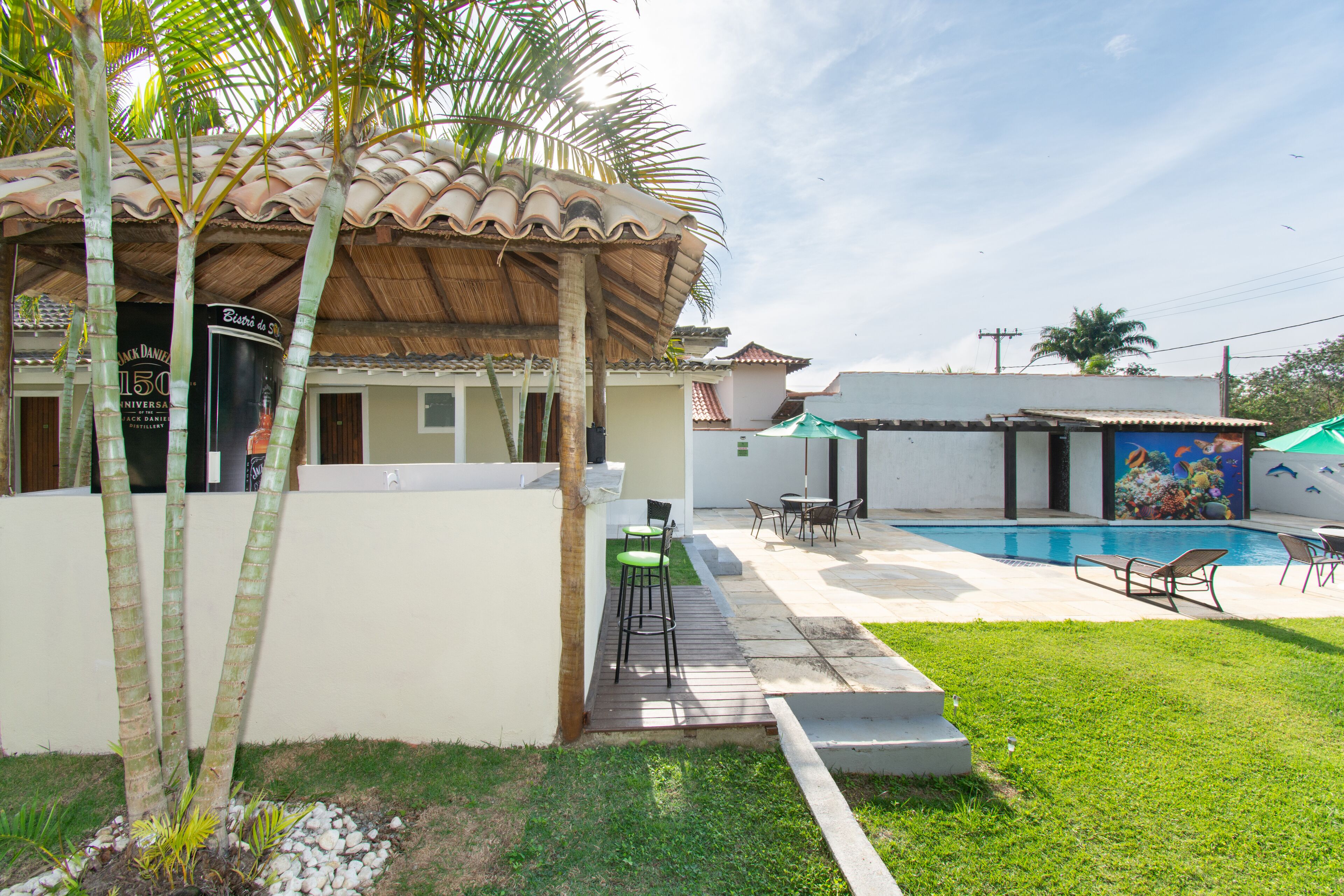 A house with a swimming pool, outdoor seating, and a mural on the side.