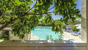 A clear blue pool surrounded by lounge chairs and a wooden deck. - Olive Garden Camp Resort (Sibenik)