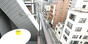 Un bâtiment moderne doté d’un toit à pente unique, situé dans une rue étroite et bordé d’immeubles d’habitation.