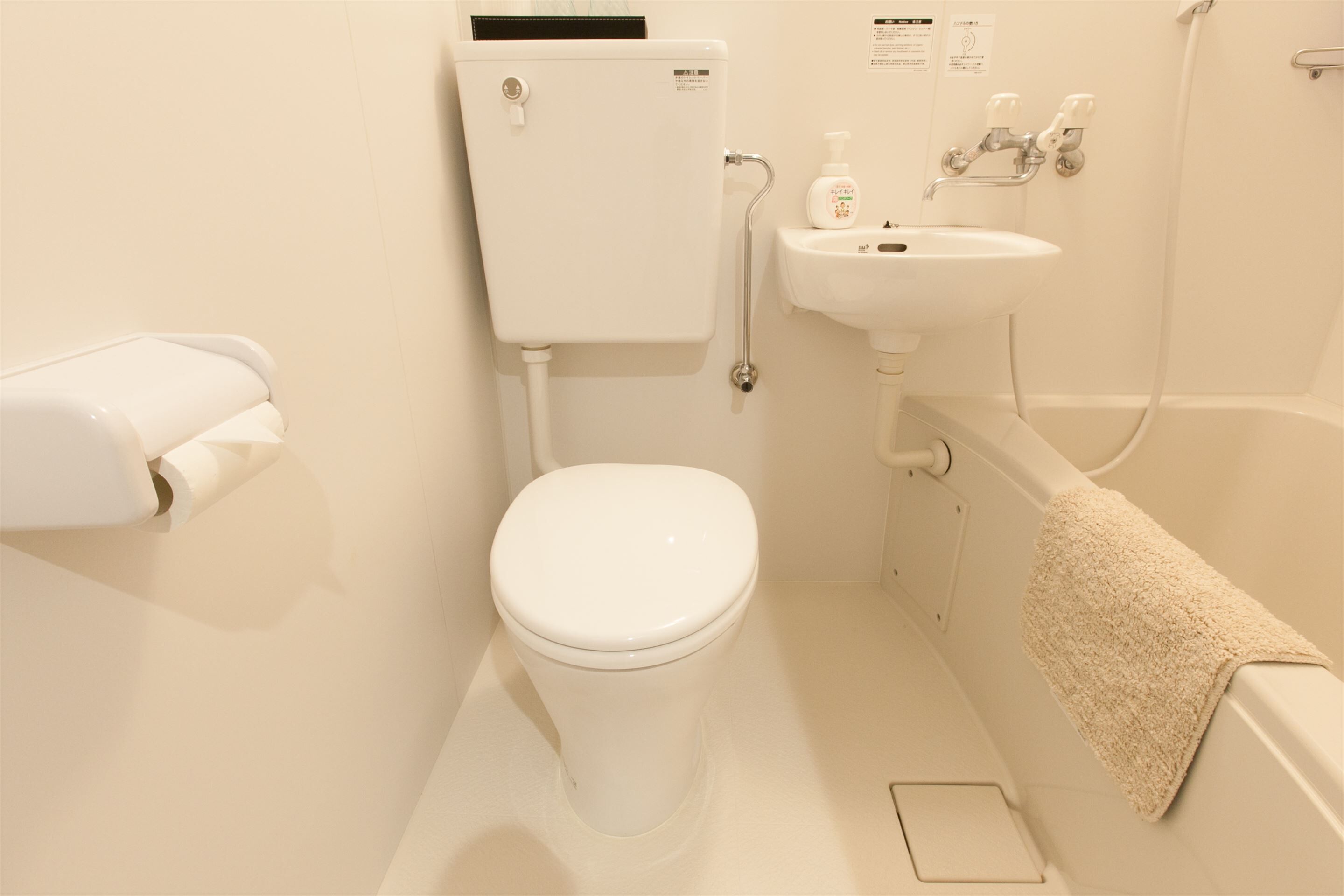 A bathroom with a toilet, sink, and bathtub.