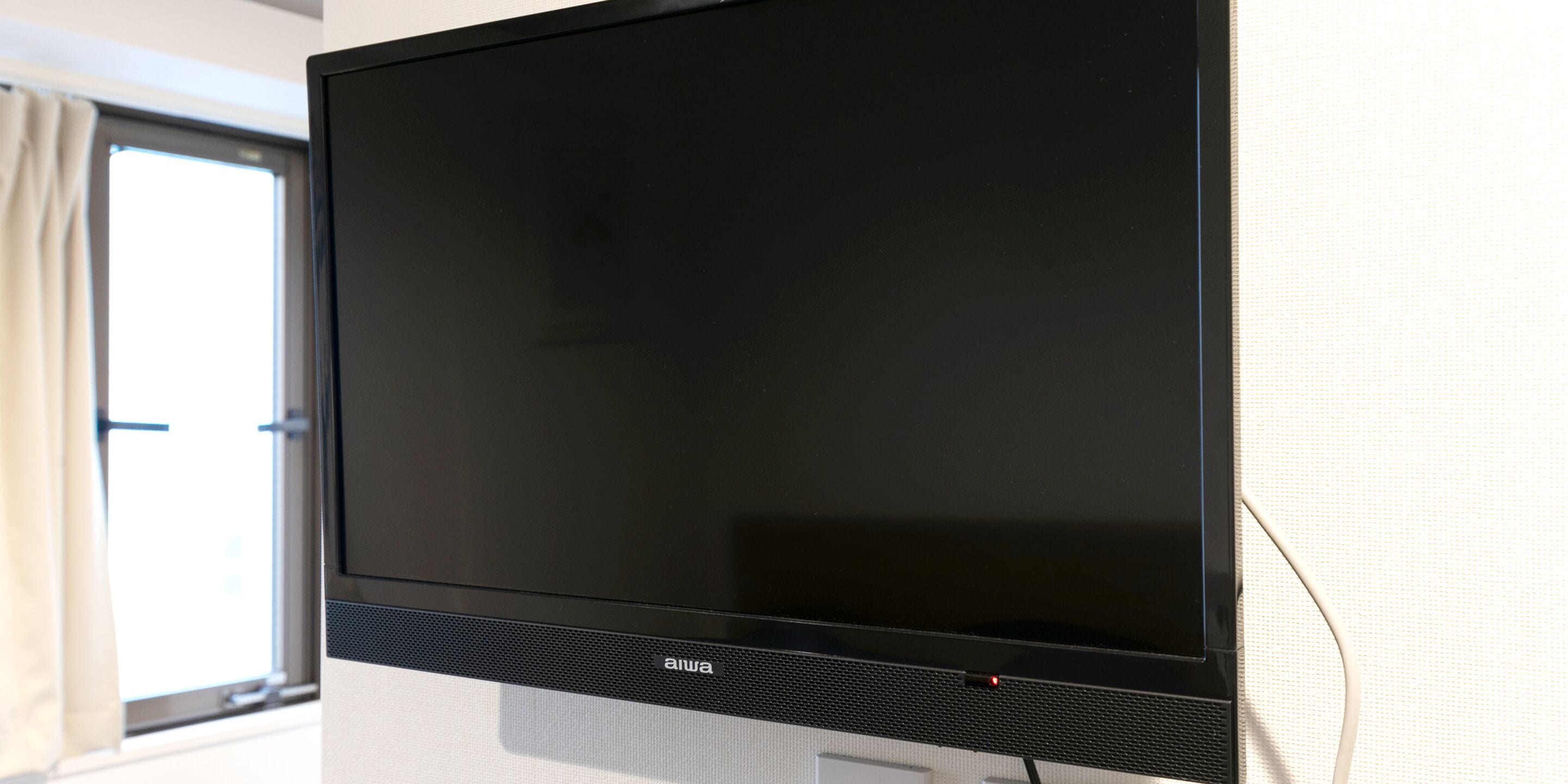 A flat-screen TV mounted on a wall with a visible brand logo.