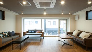 A modern living room with two sofas, a coffee table, and a large window with a view of buildings.