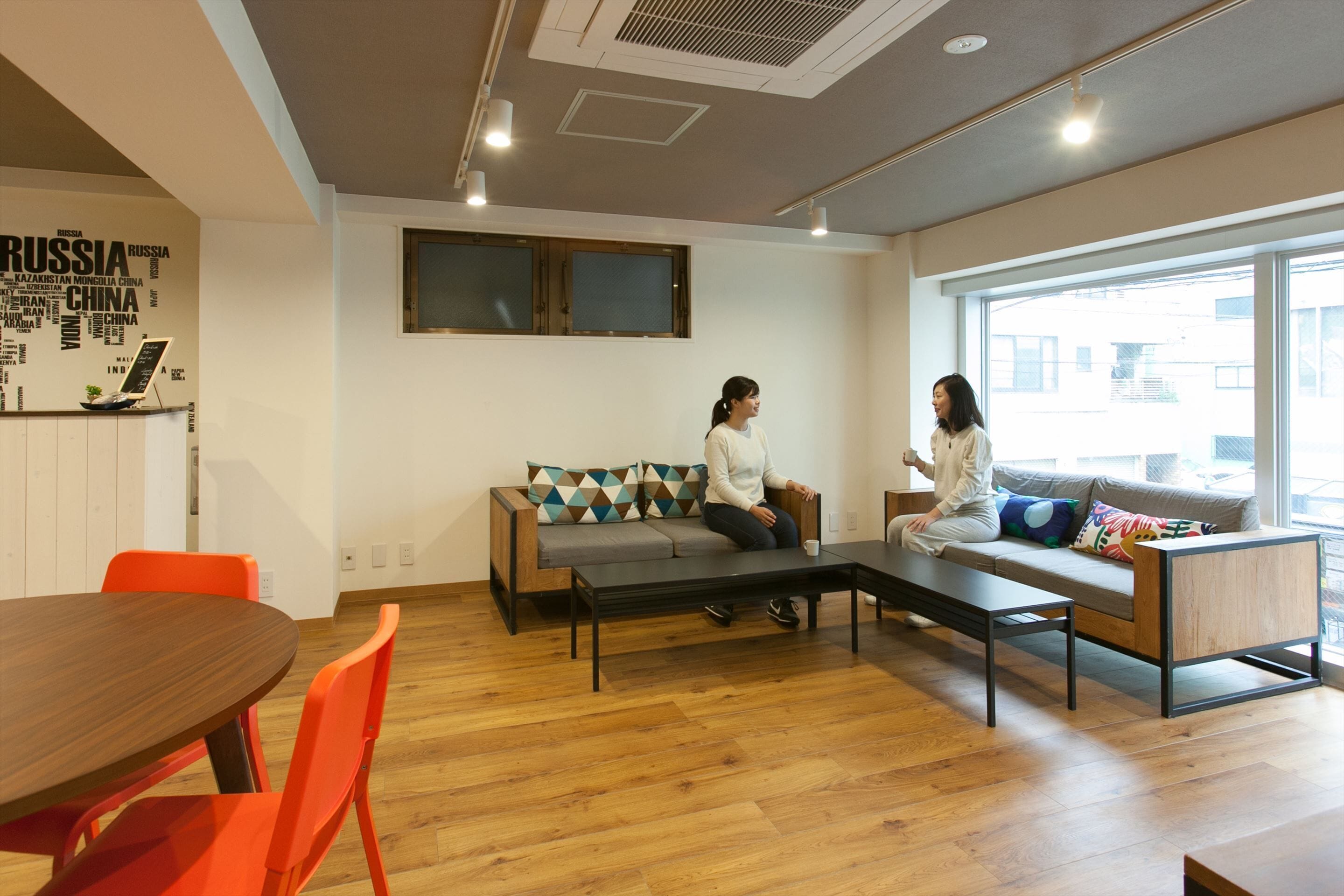 Una sala moderna con un sofá, una mesa baja y una mesa de comedor con sillas.