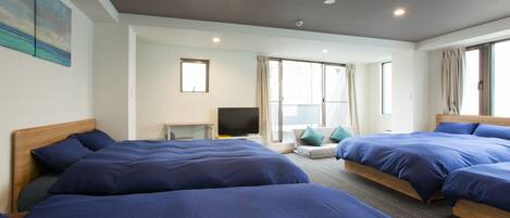 Habitación de hotel con dos camas, televisión y ventana con cortinas.
