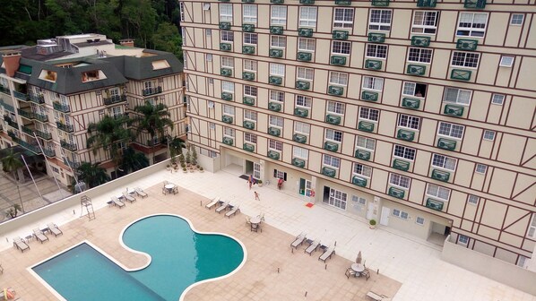 A hotel with multiple floors, a rooftop pool, and outdoor seating areas.