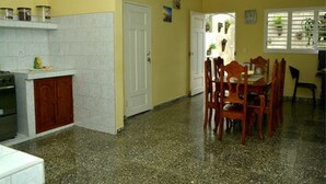 Una cocina con estufa, armarios y un comedor con sillas y mesa.