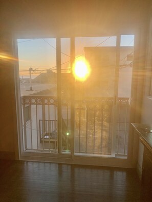 Enjoy a view of the outside from the large window, which features a metal railing and a staircase leading to an outdoor area.