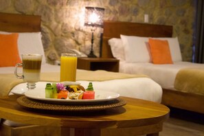 A breakfast table with a plate of food, a glass of juice, and a mug of coffee in a hotel room. - Hotel Boutique Camino del Bosque by Rotamundos (San Pedro Cholula)