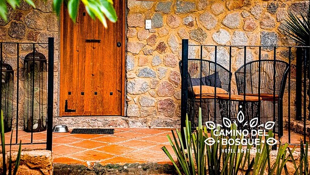 Um edifício de pedra com uma porta de madeira identificada como