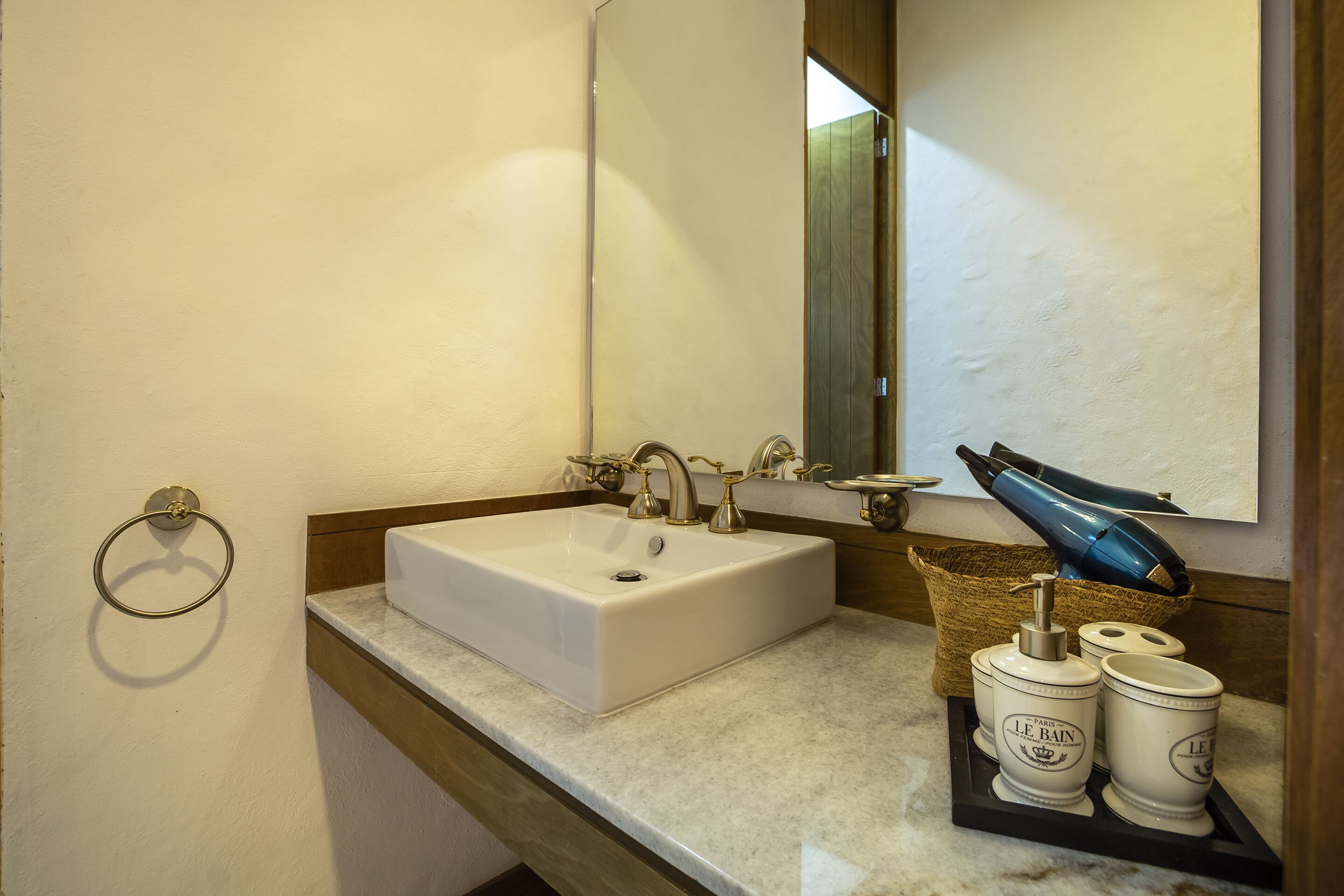 Ein Badezimmer mit Waschbecken, Spiegel und Handtuchhalter.