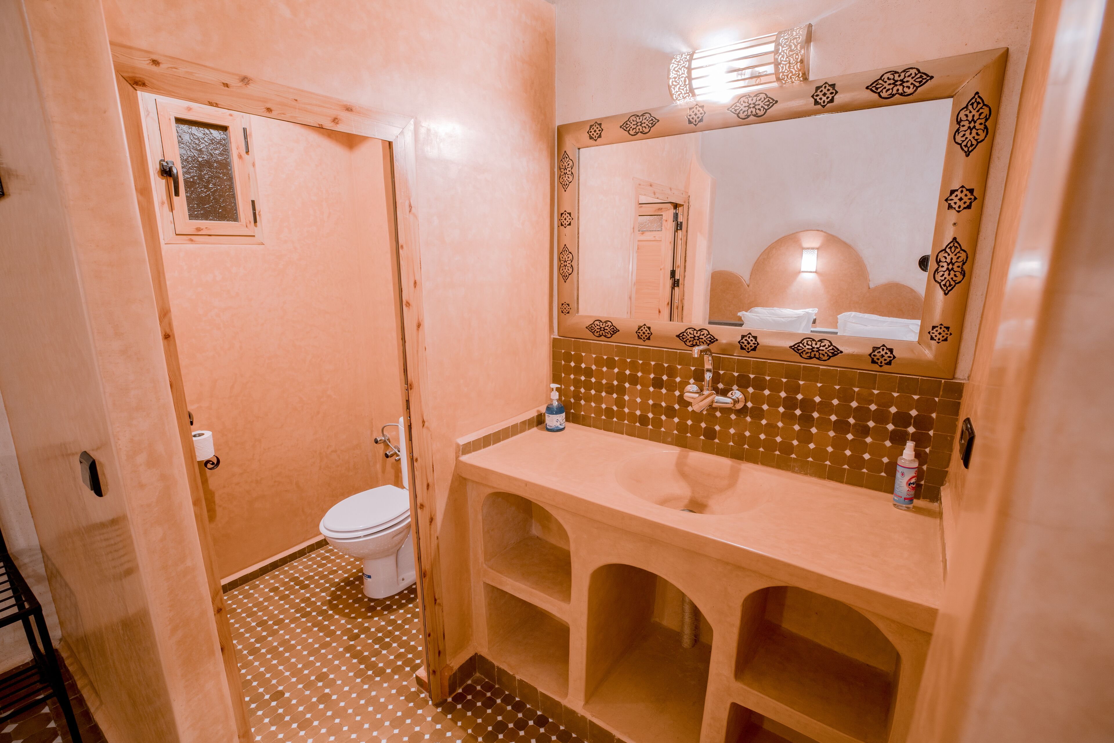 Un baño con inodoro, lavamanos y espejo.