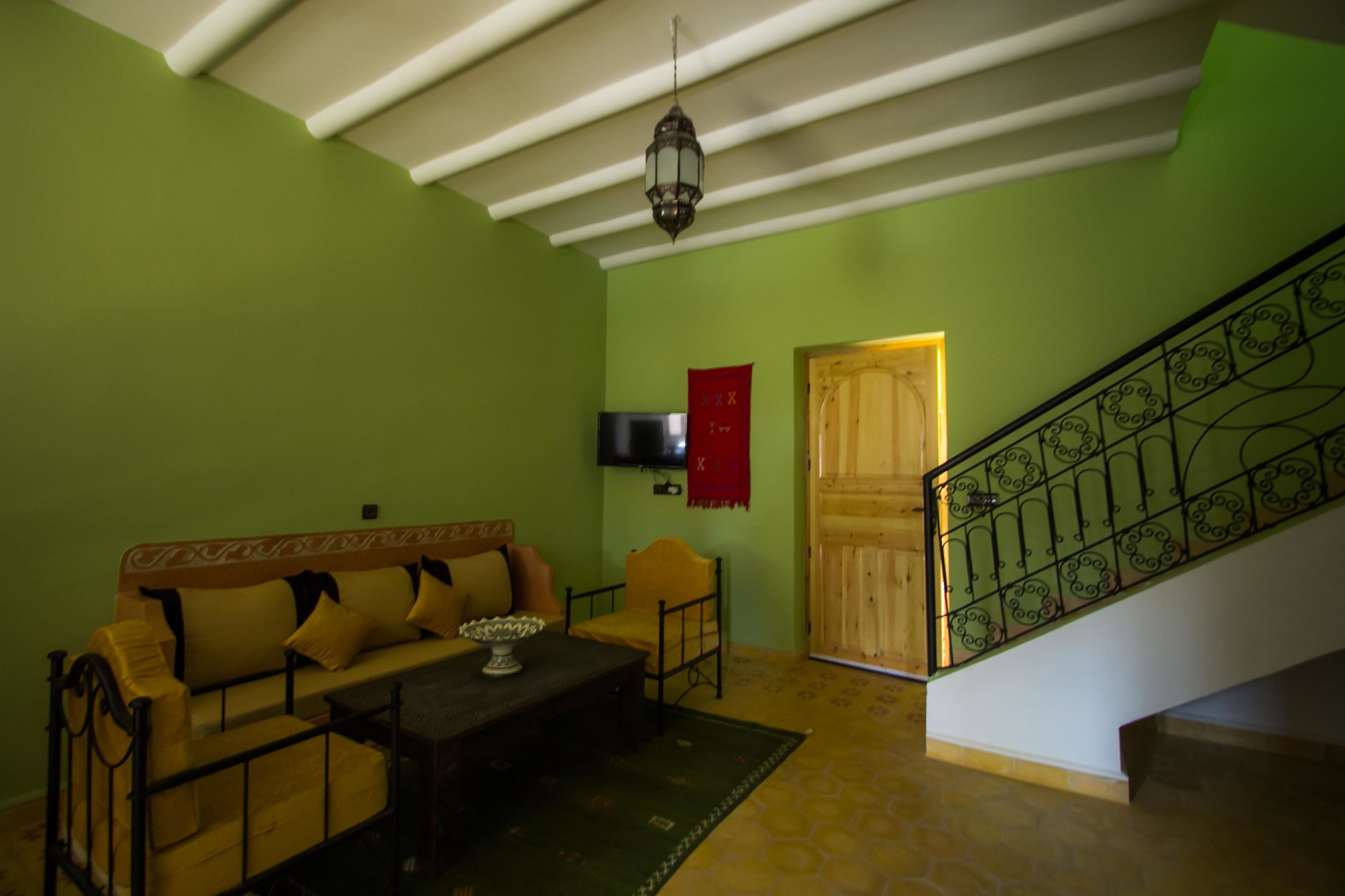 Una sala de estar con un sofá, una mesa de centro y un televisor montado en la pared.