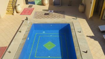 Alberca al aire libre y camastros