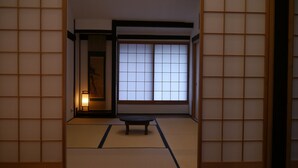 Une pièce de style japonais traditionnel, avec un sol recouvert de tatamis, des portes coulissantes en papier de riz (shoji) et une petite table basse.