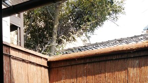 Une clôture en bois avec un pot de fleurs devant.