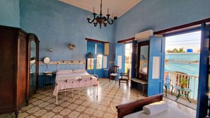 Traditional room with a bed, wardrobe, and mirror, offering a view of the outside.