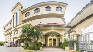 A multi-story hotel with a curved facade, a central entrance with steps, and a gated driveway. - Hotel Miramar Inn (Ciudad Madero)