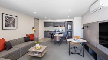 A modern living room with a sofa, coffee table, and dining area.