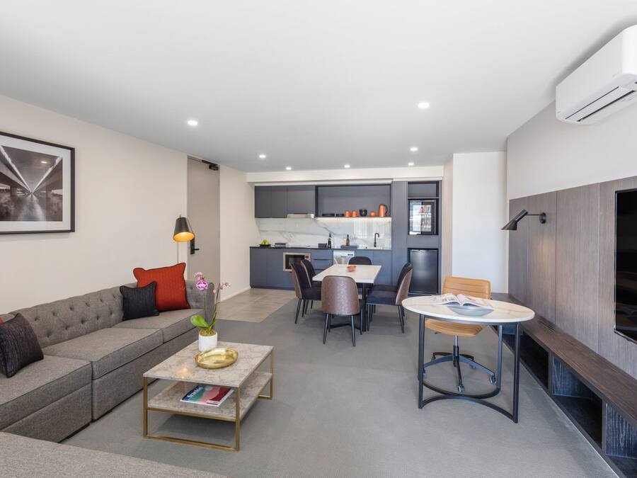 A modern living room with a sofa, coffee table, and dining area.