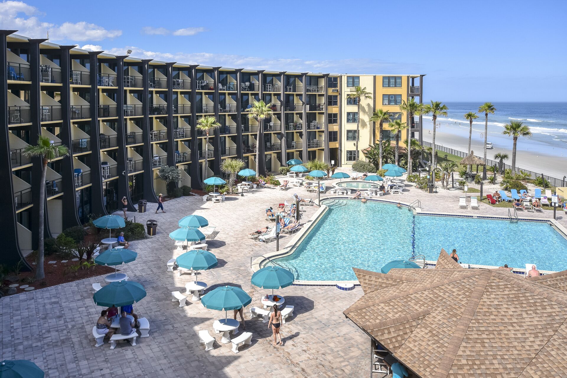 Un hotel con piscina, vista al mar y varios balcones.