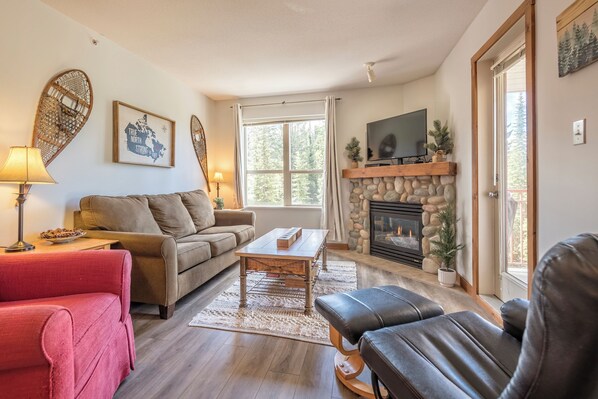 A cozy living room with a fireplace, a television, and a comfortable seating area.