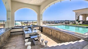 A rooftop pool area with a bar, seating, and a view of the ocean. - Poolside Fun & Beachfront Views! Galveston Condo (Galveston)